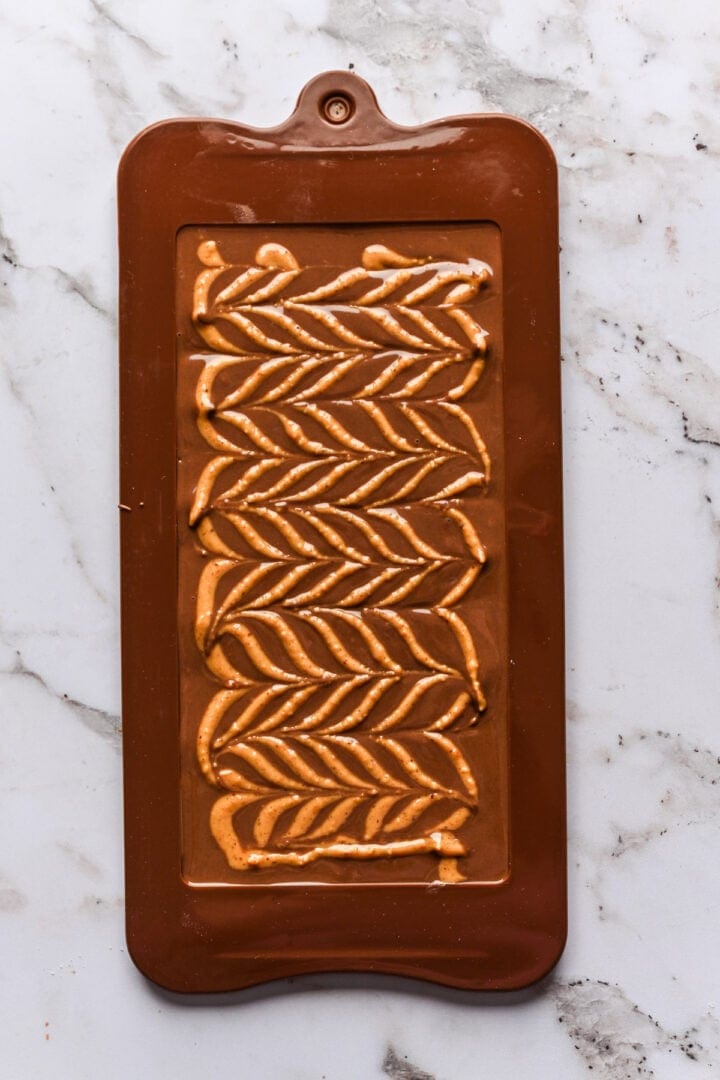 Overhead view of peanut butter design on chocolate bar.