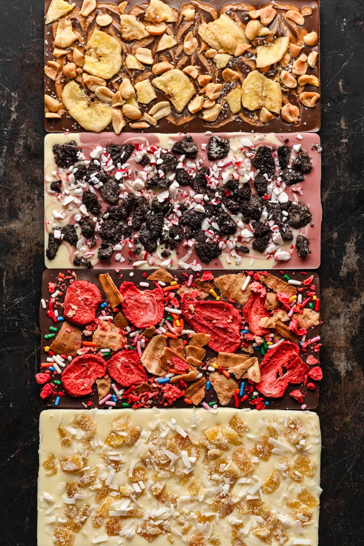 Overhead view of four chocolate bars with varied toppings.