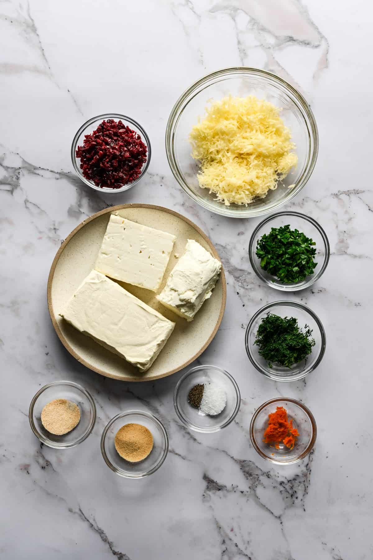 Overhead view of ingredients to make homemade christmas tree cheese ball in small bowls.