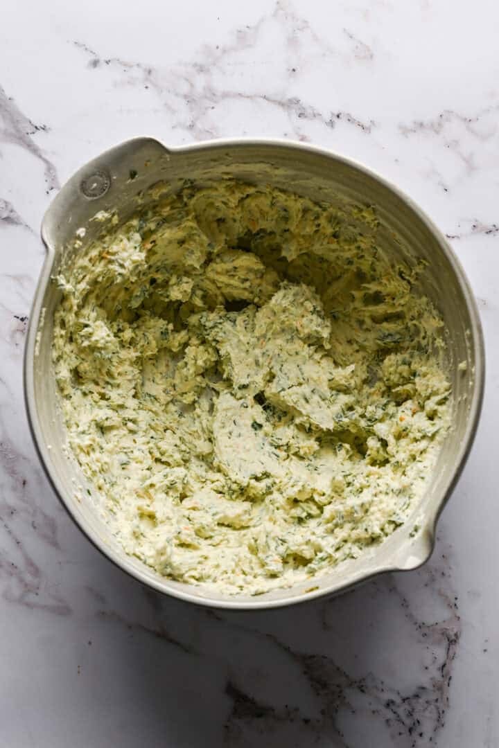 Cheeseball mixture in a white mixing bowl.