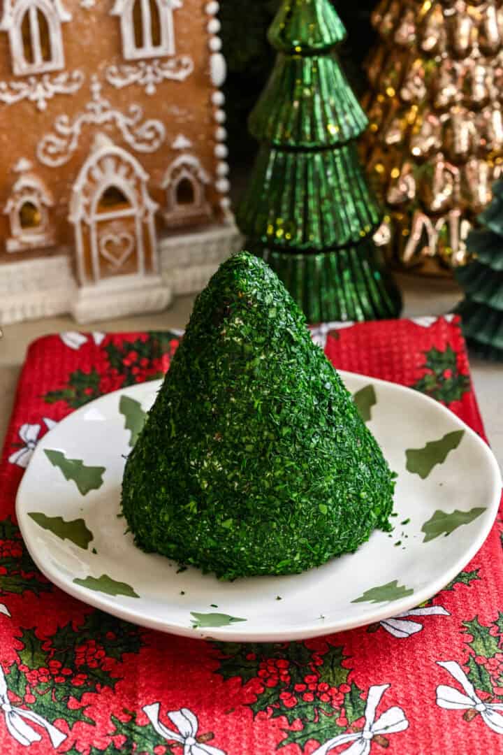 Cheese ball mixture shaped into a cone and covered in chopped parsley and dill.