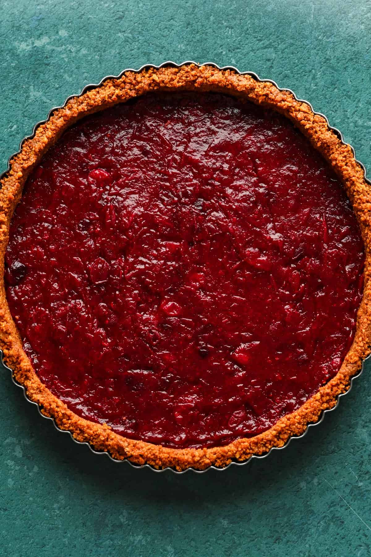 Gingersnap tart crust filled with a layer of cranberry compote.