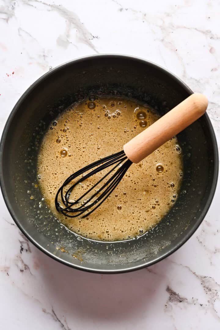Brown sugar and eggs whisked together in a bowl.