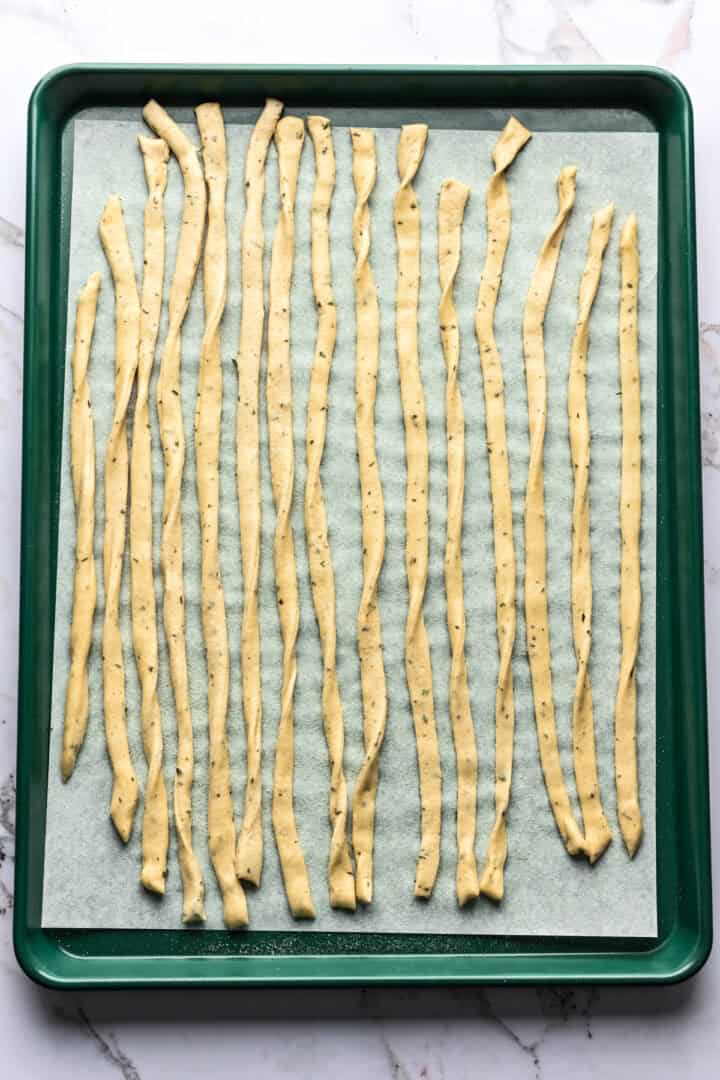 Overhead view of breadsticks on parchment.