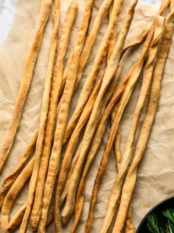 Overhead view of breadsticks on parchment.