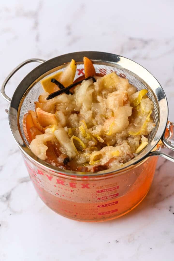Pears and vanilla bean in a strainer to strain the infused vodka.