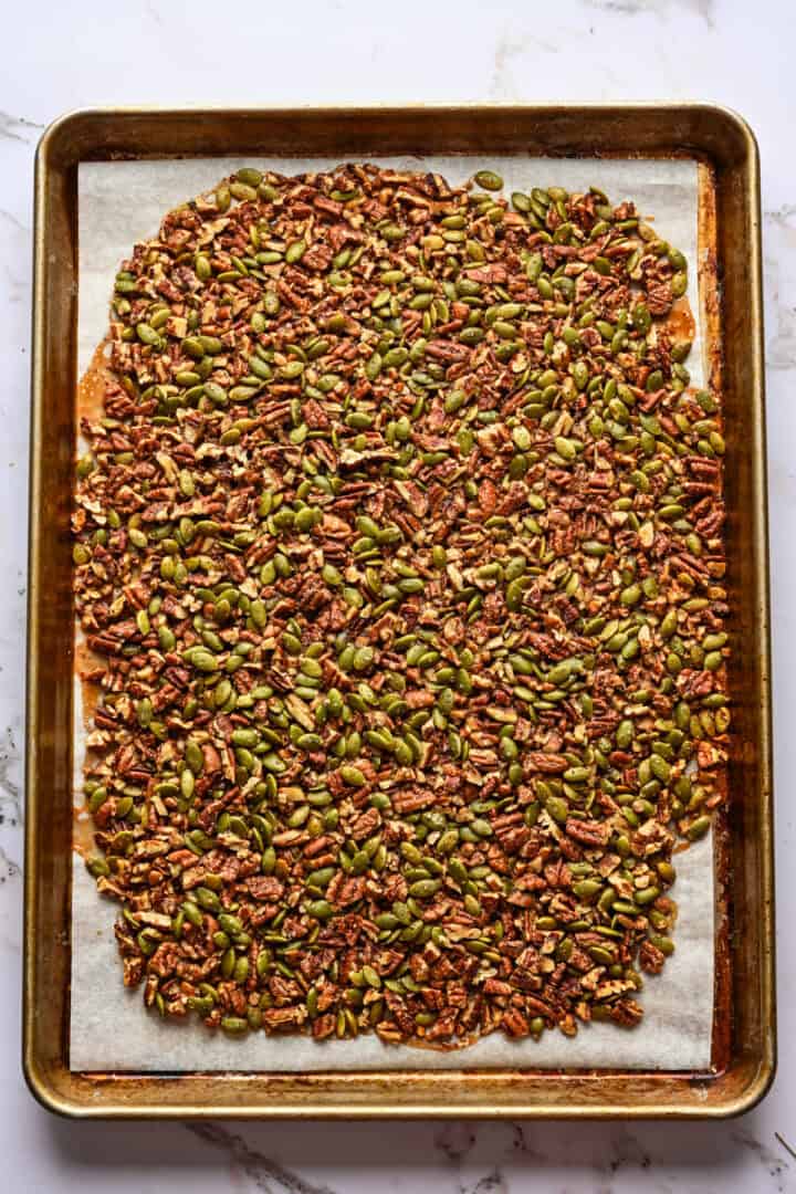 Pecan pepita brittle on baking sheet after baking.