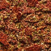 Pecan pepita brittle on baking sheet after baking, broken up into pieces.