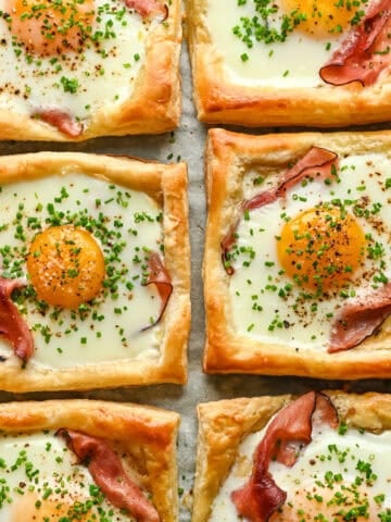 Overhead view of several croque madame on a sheet pan.