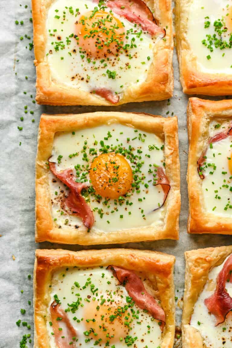 Overhead view of several croque madame on a sheet pan.