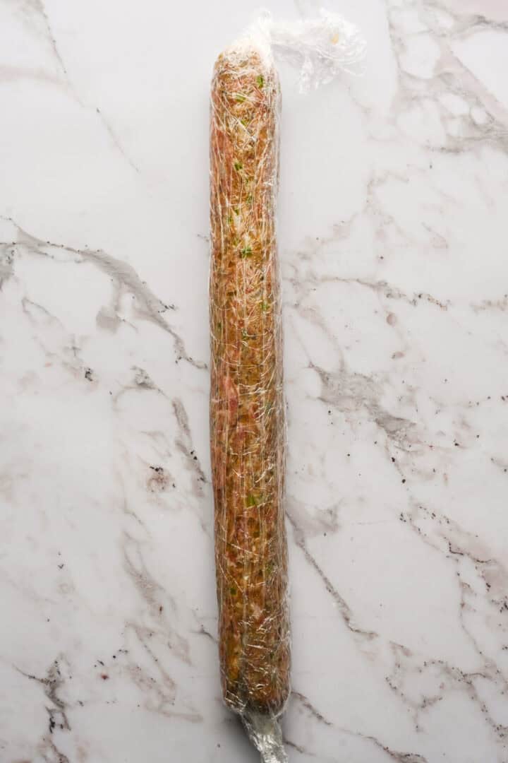 An 18-inch log of sausage wrapped in plastic wrap.