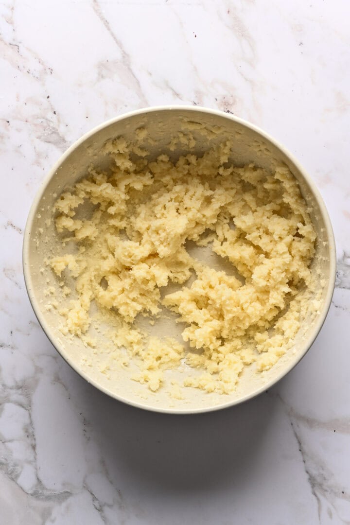Butter and sugar creamed in a white mixing bowl.