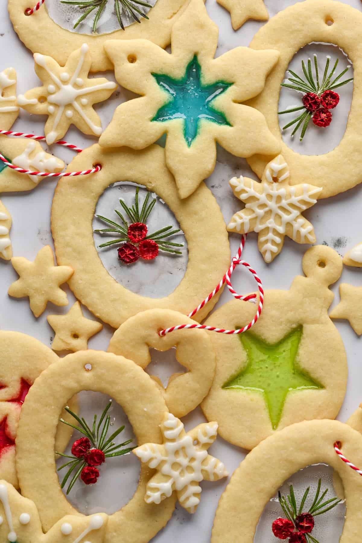 Overhead view of stained glass cookie ornaments on white backdrop.