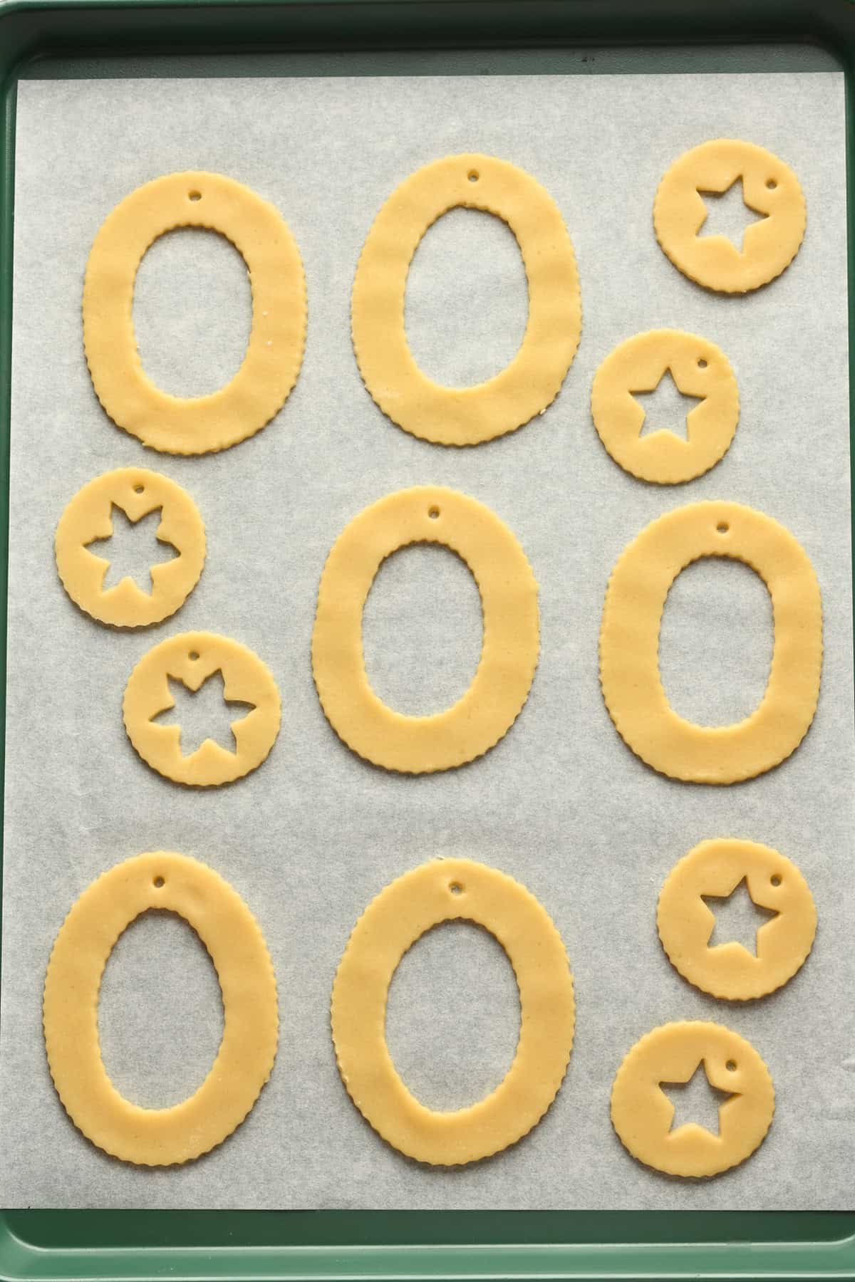 sugar cookie dough cut into ovals and circles with the centers cut out.