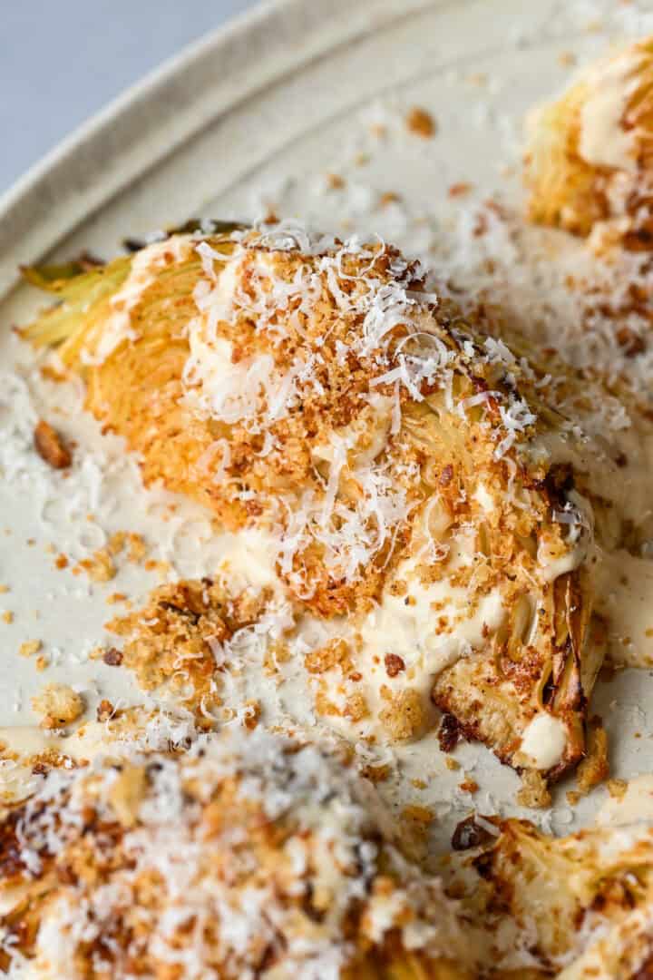 Overhead view of cabbage wedge with caesar dressing and parmesan.