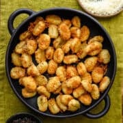 Crispy cacio e pepe air fryer gnocchi in a black bowl.