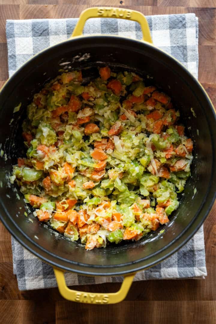 Overhead view of carrots and celery coated in a roux.