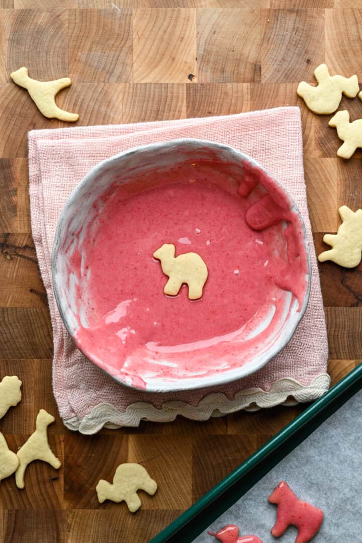 Overhead view of frosted animal cookie dipped in frosting.