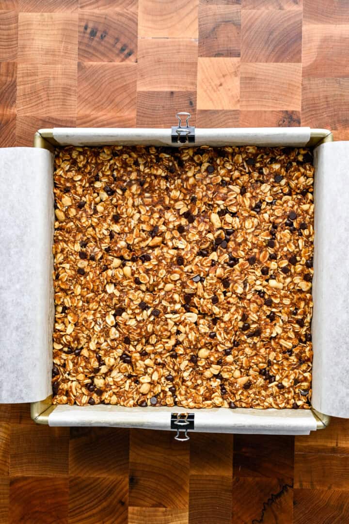 Granola bar mixture pressed into baking pan.