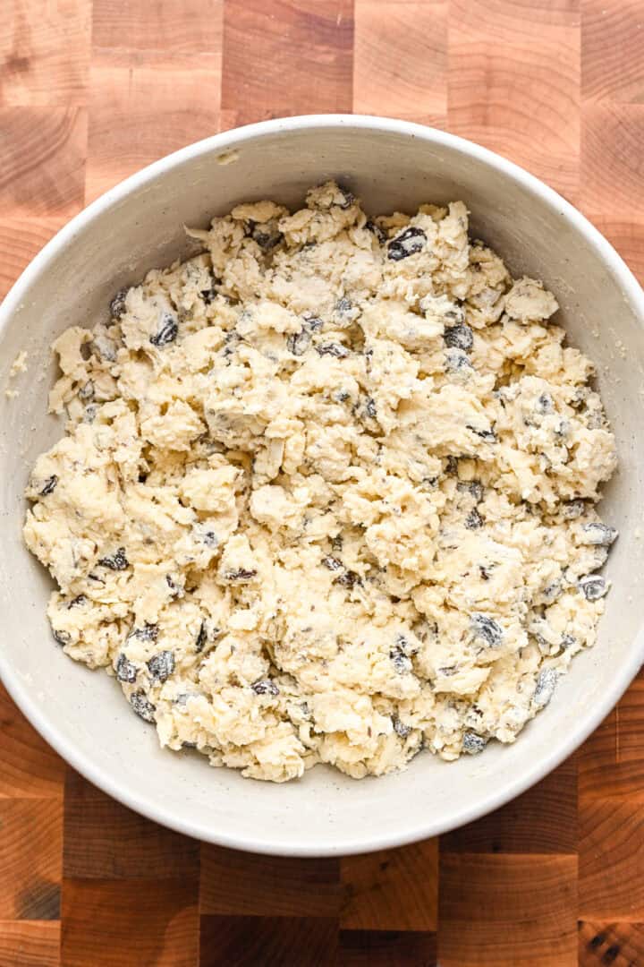 irish soda bread scone dough after it forms a shaggy dough in a bowl.