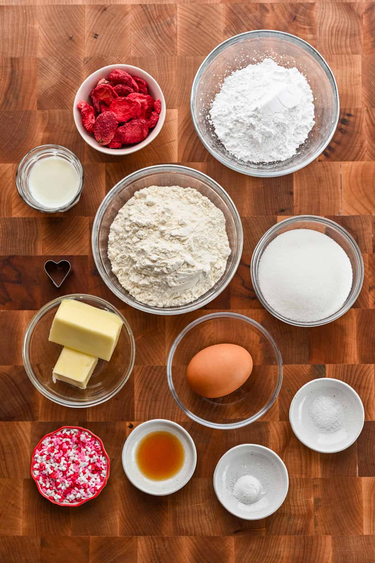 Ingredients for mini heart sugar cookies in separate bowls.