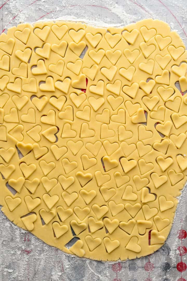 Mini heart cookies cut out of cookie dough.