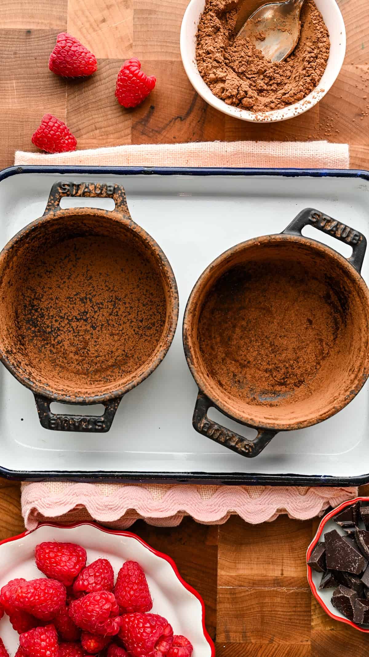 2 cast iron ramekins dusted with cocoa powder.