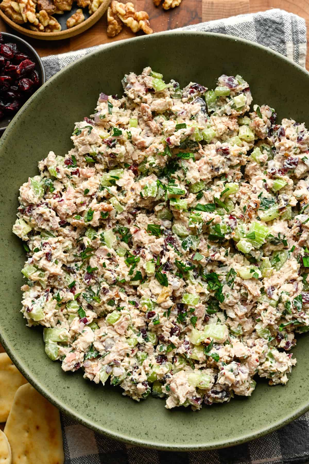 Close up view of cranberry walnut chicken salad in a green mixing bowl.