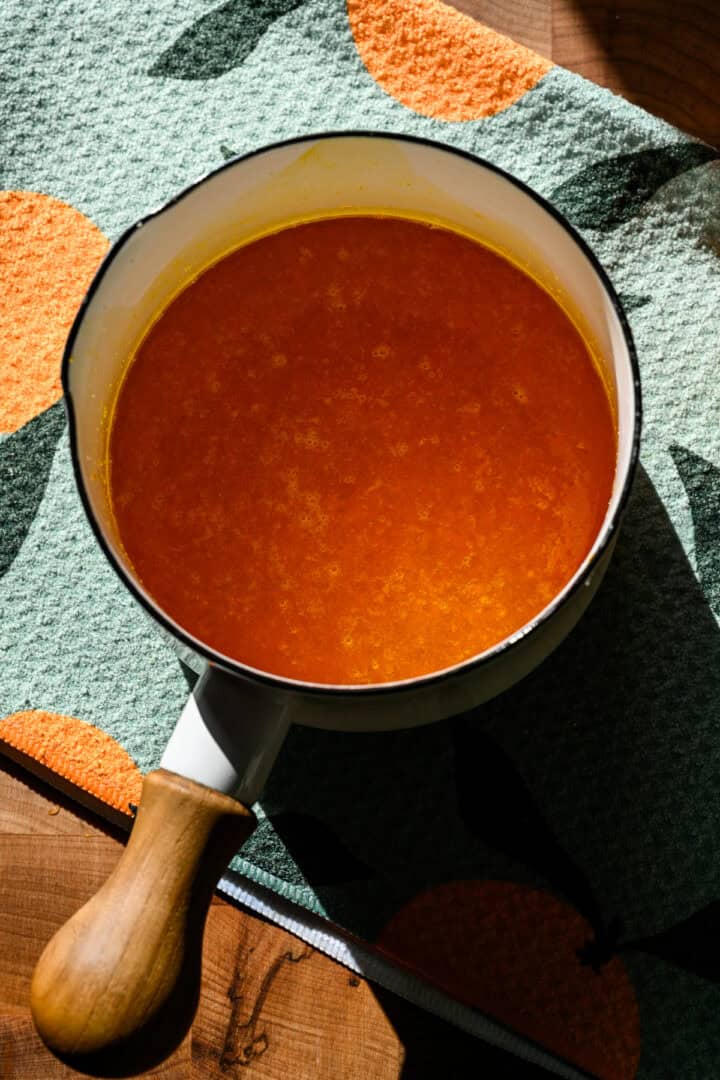 Orange soda syrup in a saucepan.
