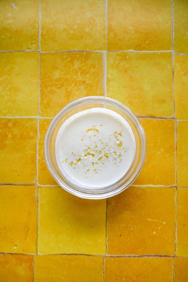 Heavy cream and lemon zest in a bowl.