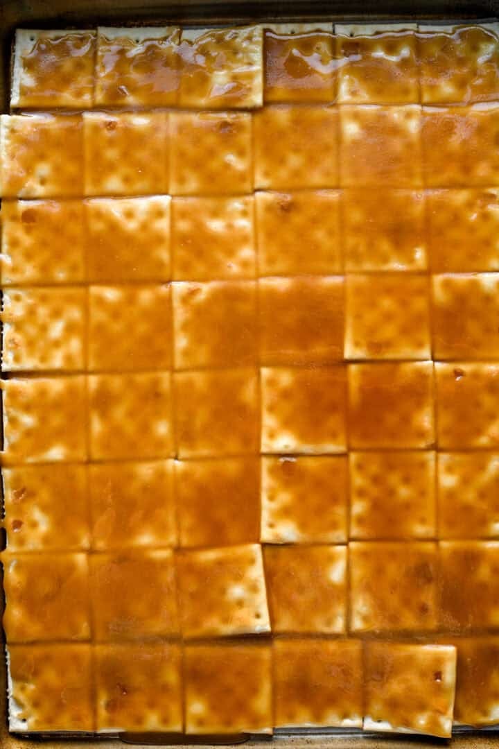 Overhead view of saltines after spreading caramel over the top of them.
