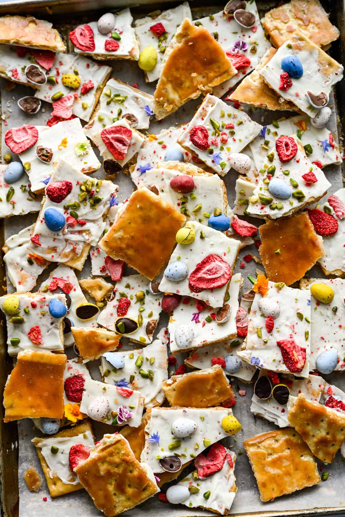 Pieces of easter crack all stacked on top of one another on a sheet pan.