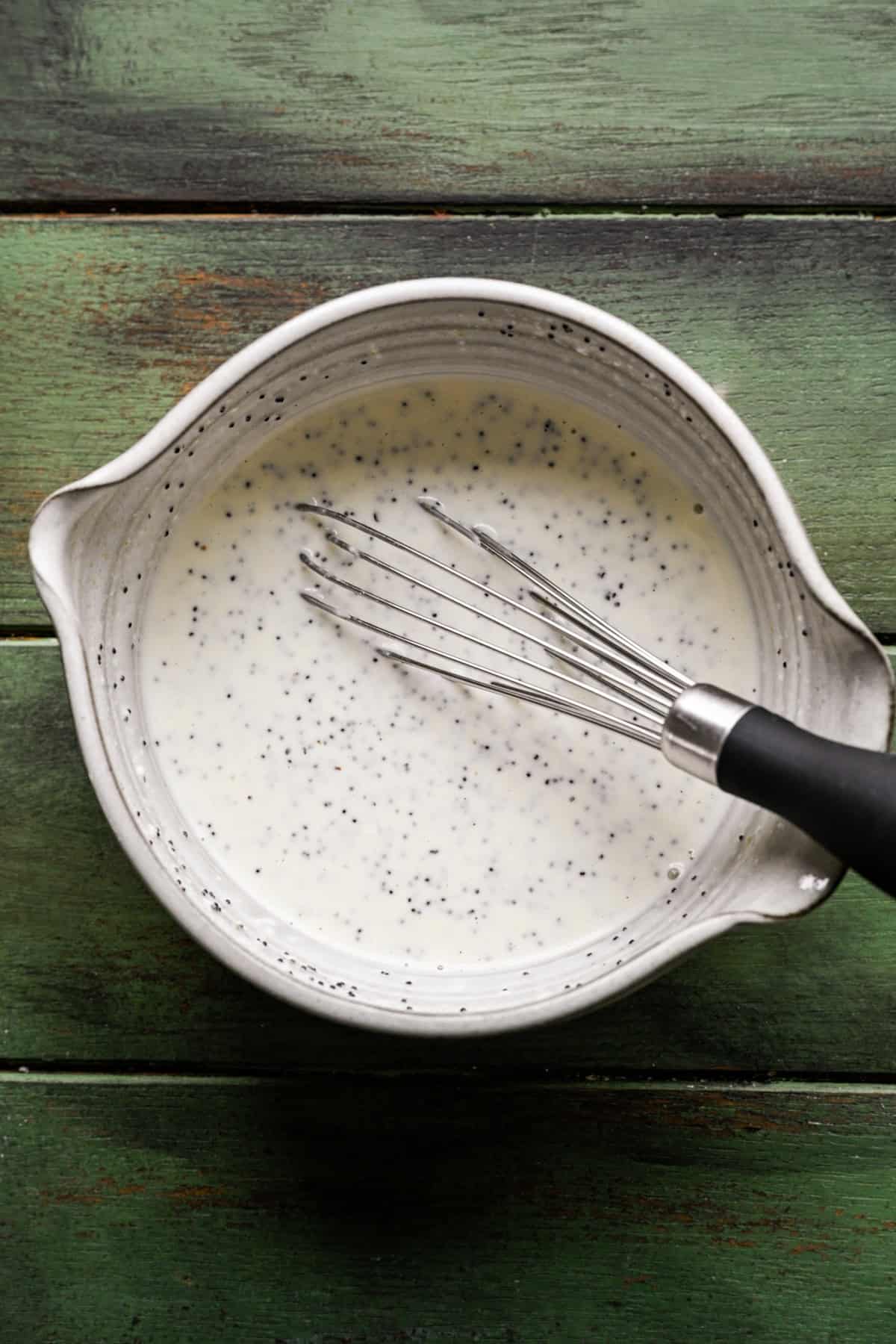 Homemade poppyseed dressing whisked in a bowl.