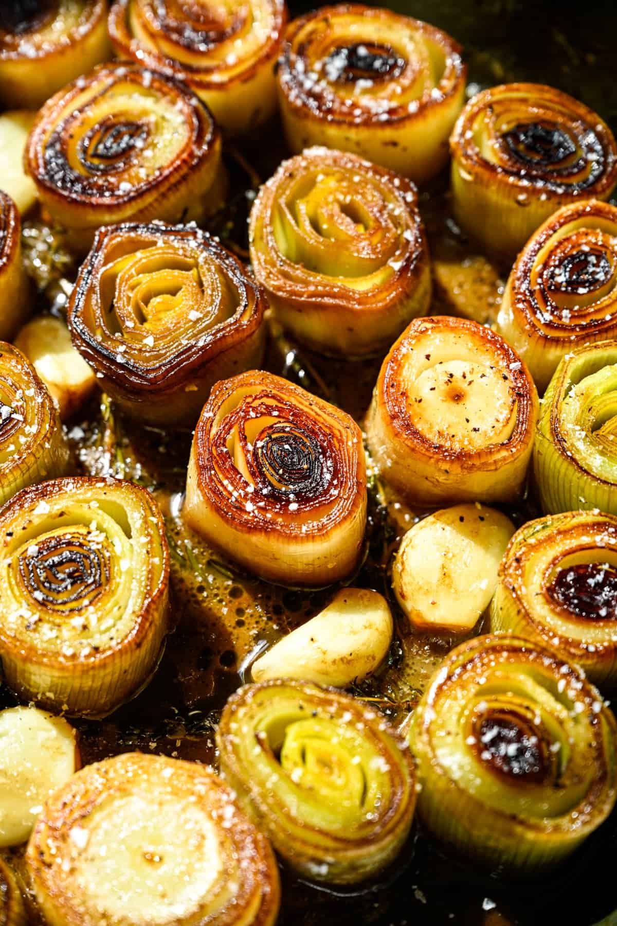 Overhead view of cooked leeks in a pan.