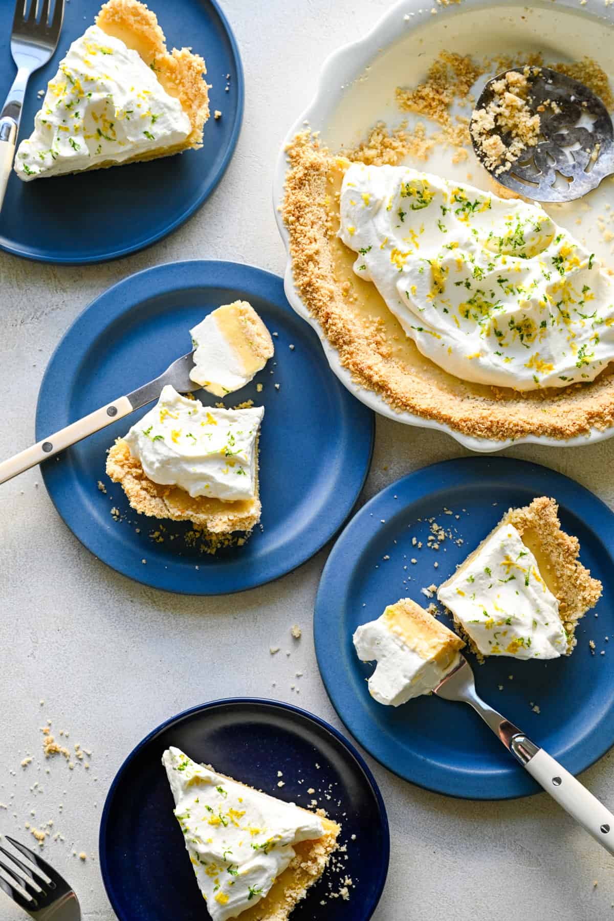 Overhead view of several slices of atlantic beach pie on blue plates next to the whole pie.