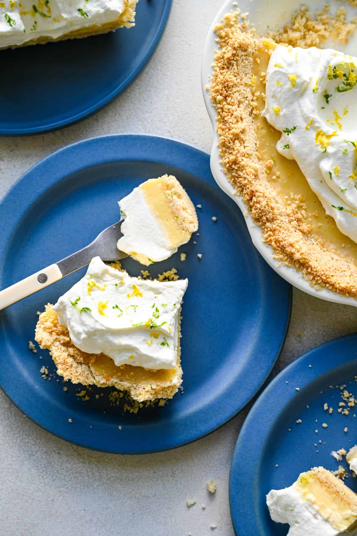 Overhead view of several slices of atlantic beach pie on blue plates next to the whole pie.
