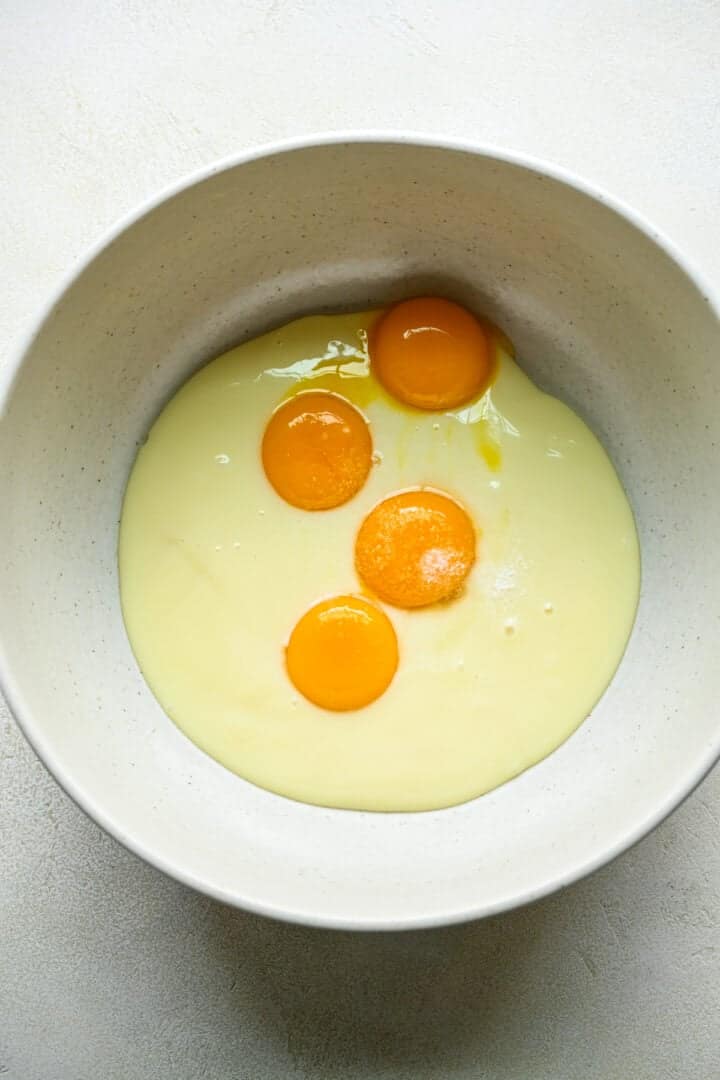 Condensed milk and egg yolks in bowl.
