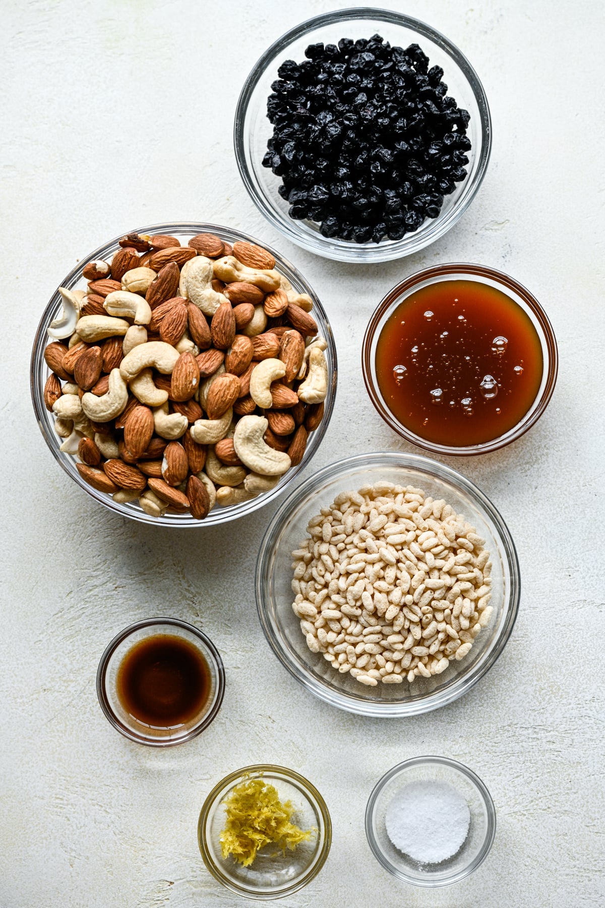 Overhead view of ingredients for blueberry cashew snack bars in small bowls.