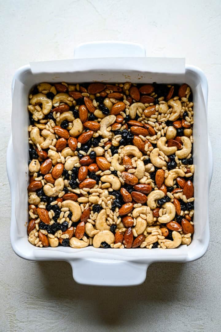 Overhead view of blueberry cashew snack bars in pan before baking.