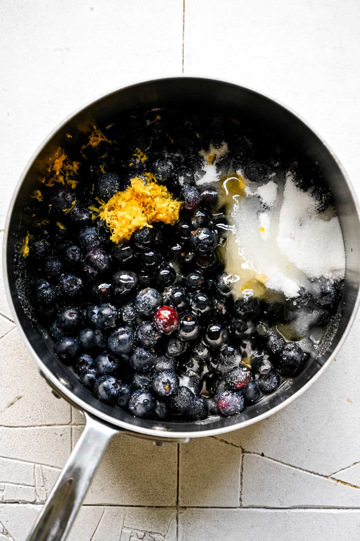 Blueberry mixture cooking in a saucepan.