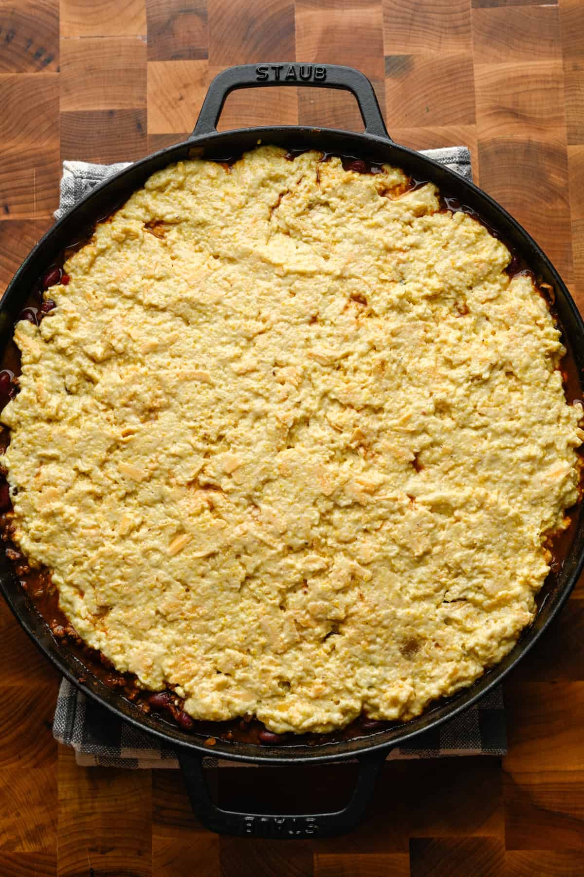 Cornbread batter spread on top of chili before baking.