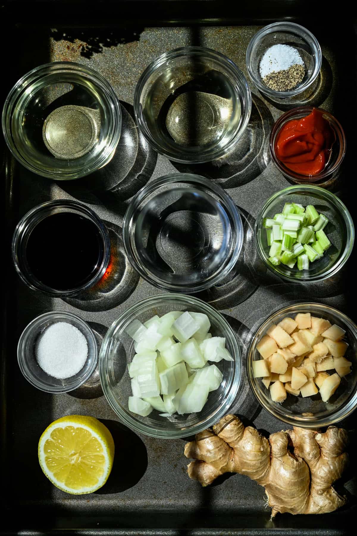 Overhead view of ingredients for homemade ginger dressing in small bowls.