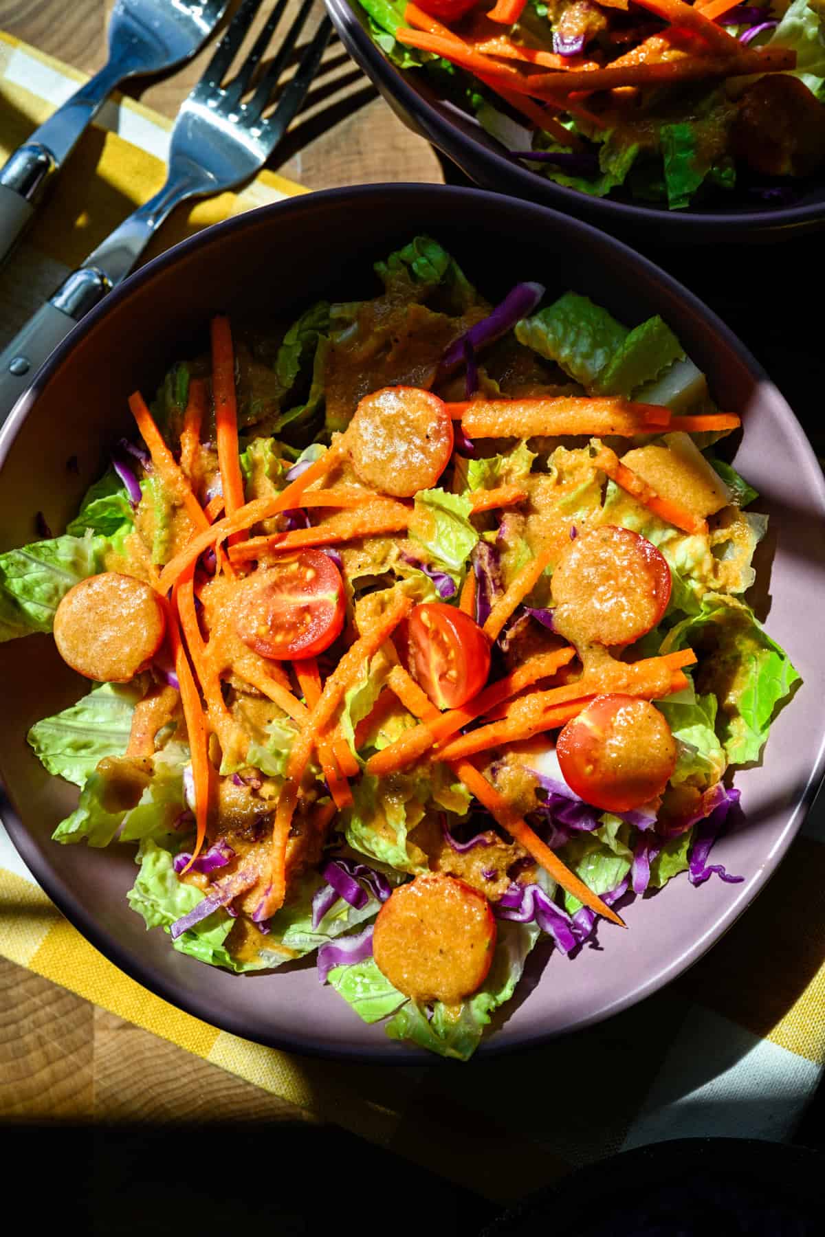 Overhead view of a simple salad drizzled with homemade ginger dressing.