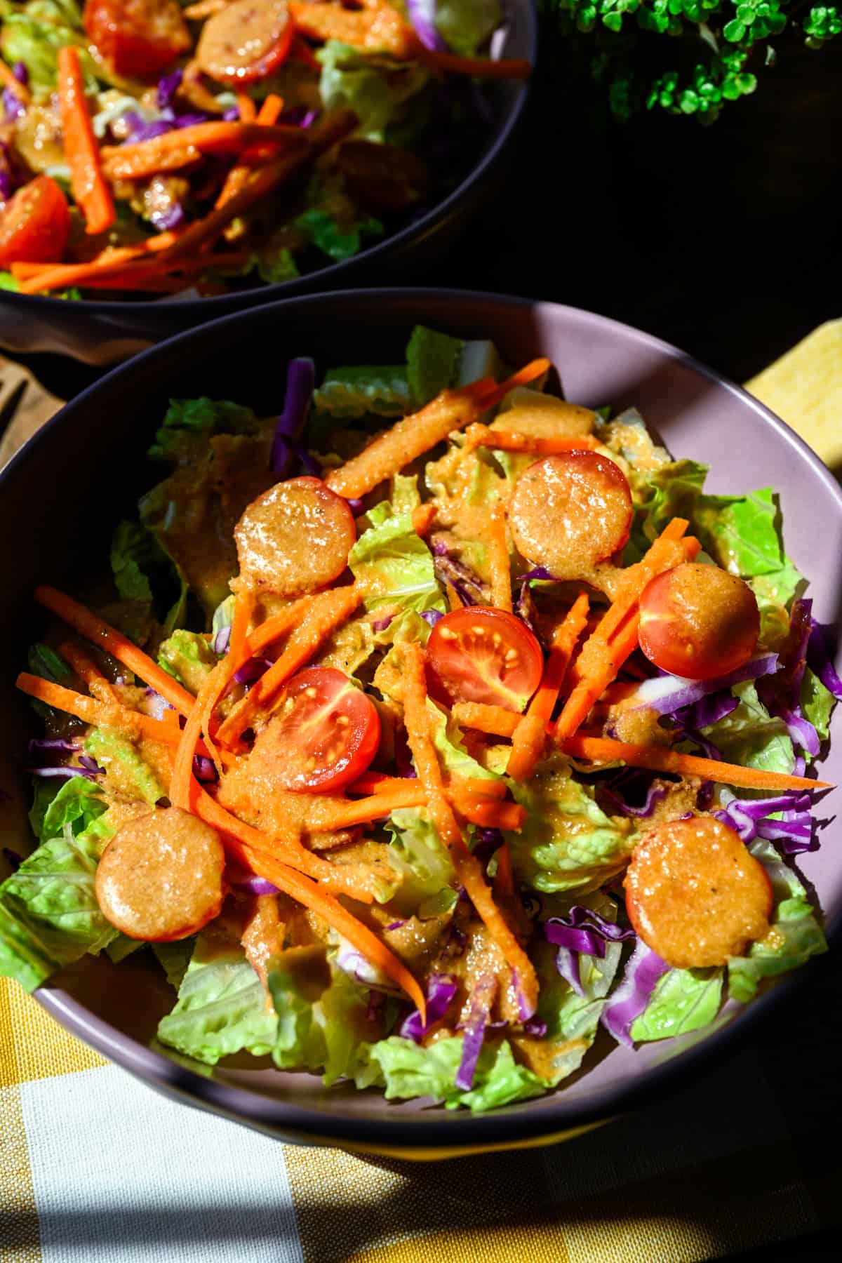 Overhead view of a simple salad drizzled with homemade ginger dressing.