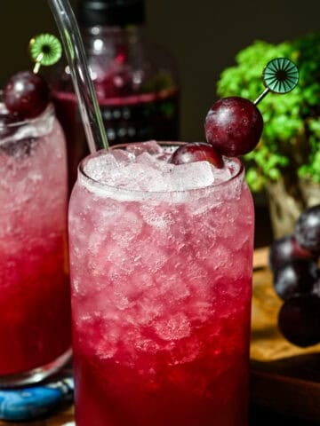 Front view of grape soda in a glass.