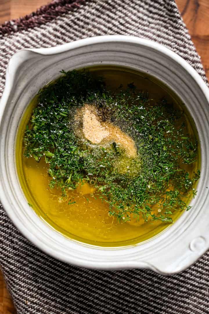 Lemon dill dressing ingredients in a bowl before whisking together.