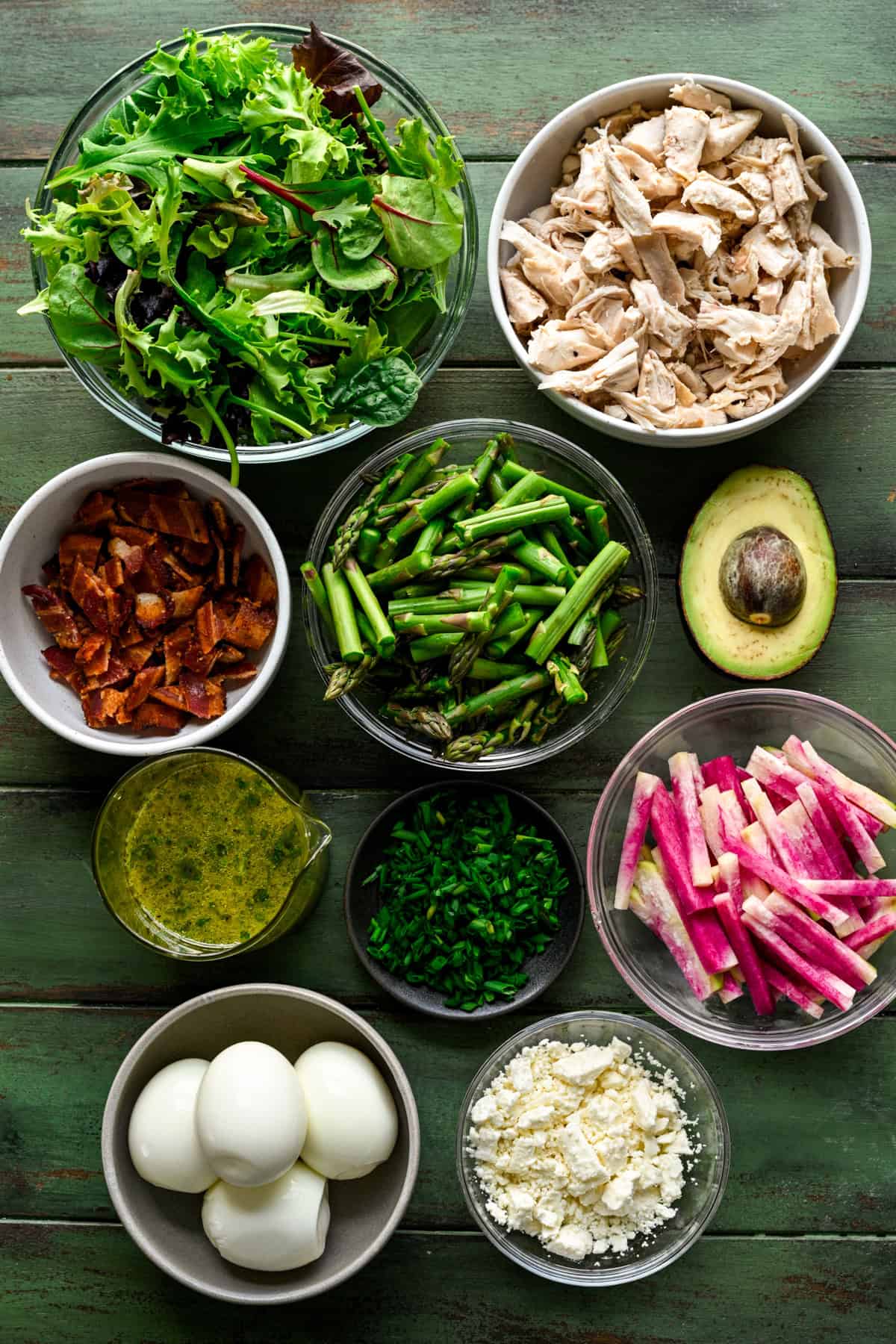 Overhead view of ingredients that go in spring cobb salad in small prep bowls.