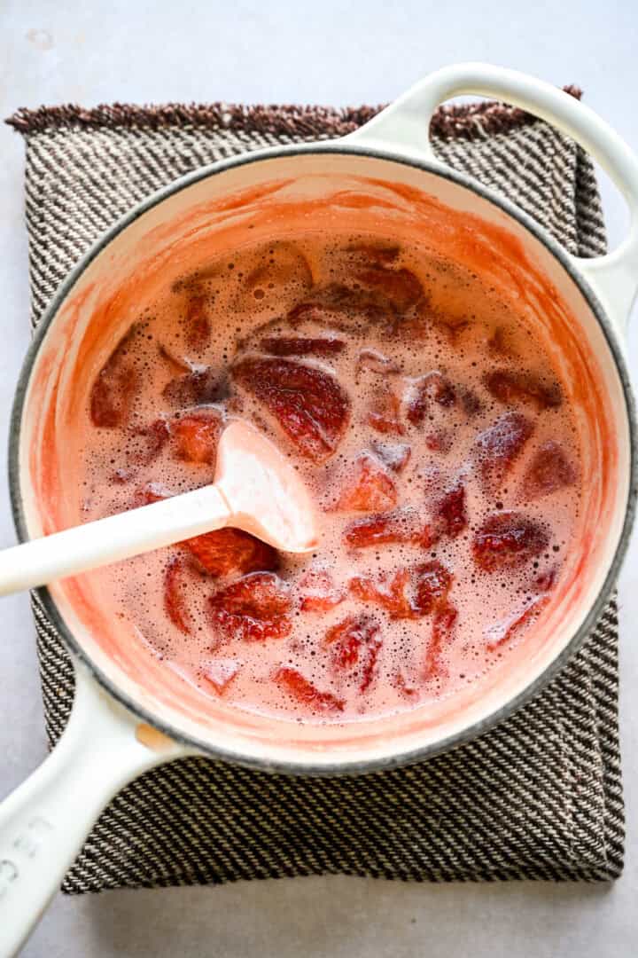 Strawberry syrup in a white pot after cooking.