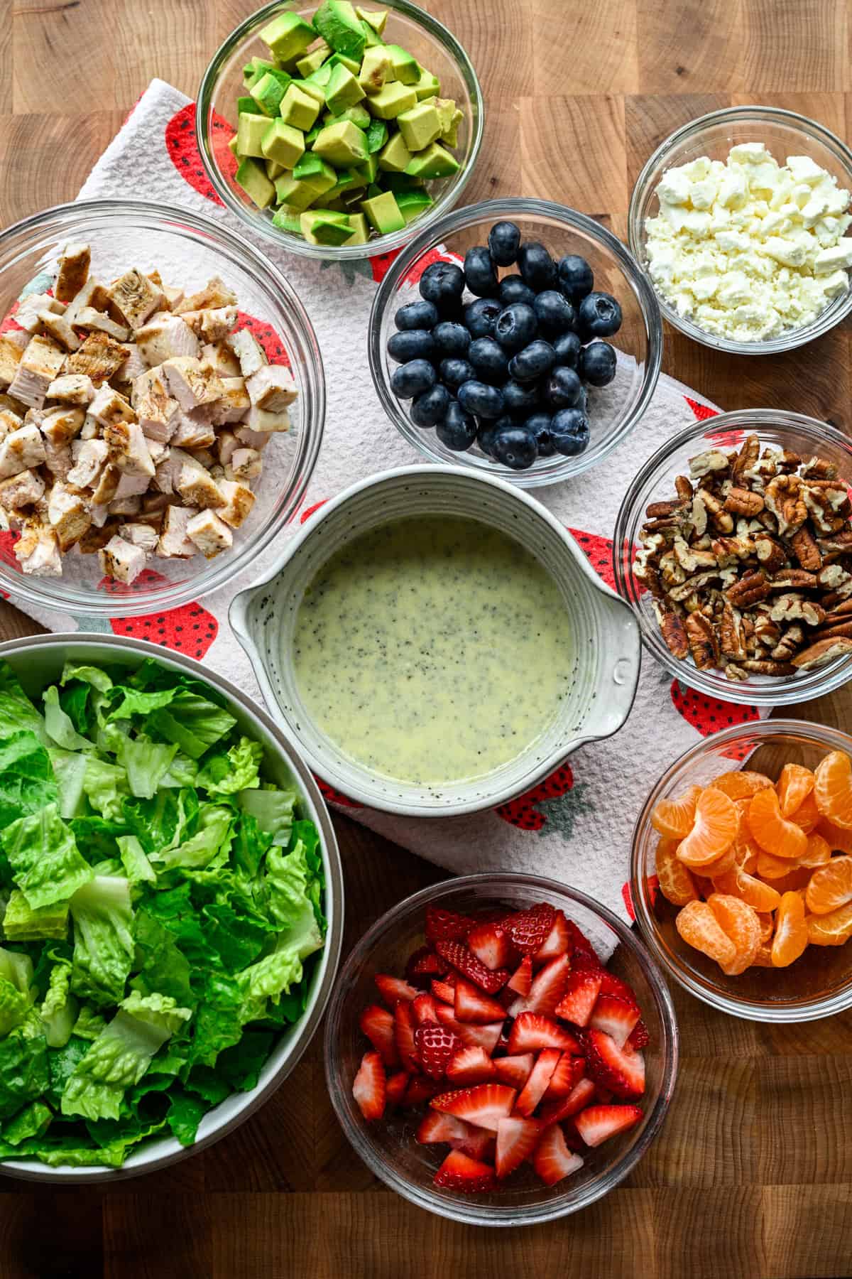 Overhead view of strawberry poppyseed ingredients, including dressing and blueberries.