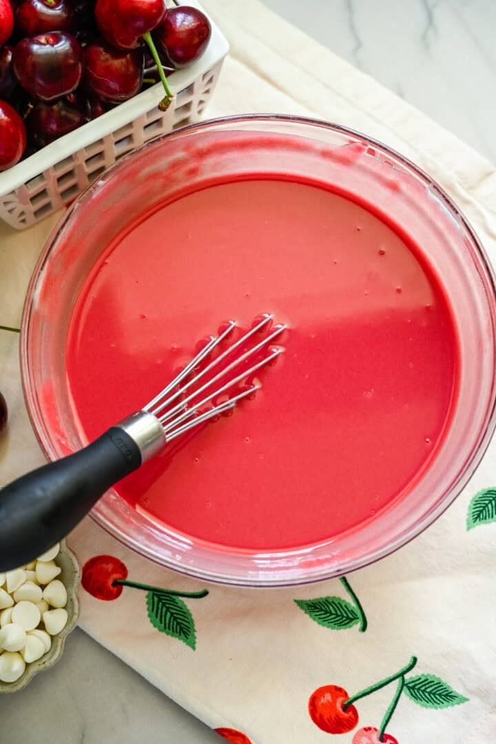 Cherry magic shell in a bowl with a whisk.